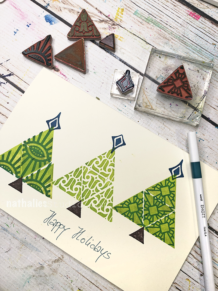 handmade card with triangle shaped trees with toppers, besides the card some triangle shaped and patterned rubberstamps that were used to create the card. 